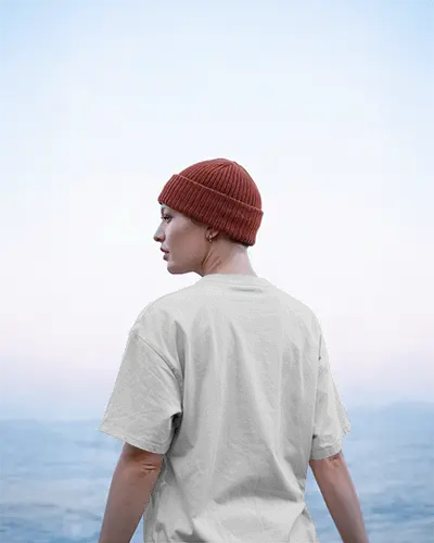 Ocean View T Shirt Back Facing Model In Red Beanie Under Soft Sky Gradient