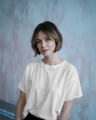Modern Portrait T Shirt Mockup Natural Look In Clean Tee Against Painted Pastel Wall