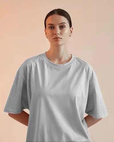 Front View Tshirt Mockup Woman In Light Gray Tee With Hair Bun Facing Camera Soft Orange Background