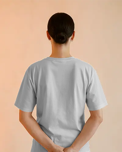 Back View Tshirt Mockup Woman In Gray Half Sleeve Tee With Hands Behind Against Soft Orange Background