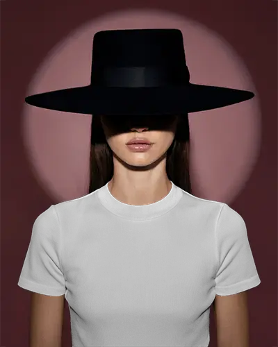 Fitted White Crew Neck Short Sleeve T Shirt Mockup Front View Female Model In Black Wide Brim Hat Shadowed Eyes Deep Maroon Backdrop Bold Minimalist Fashion Look