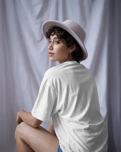Studio Lit T Shirt Mockup Back View Female Model In White Hat Soft Curtain Background Elegant Pose