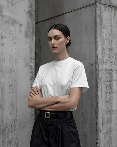Minimalist Urban Tshirt Mockup Female Model In Tshirt Against Raw Concrete Wall