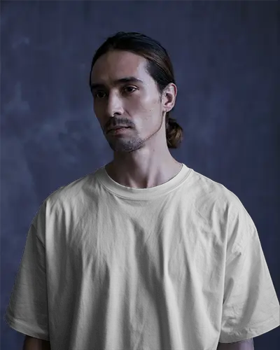 Moody Studio T Shirt Mockup Male Model In White Oversized Tee Soft Dark Background Casual Fashion Focused Expression Minimalist Style