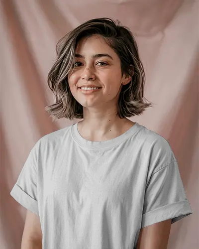 Casual T Shirt Mockup On Happy Young Woman In Front Of Gentle Blush Pink Studio Backdrop
