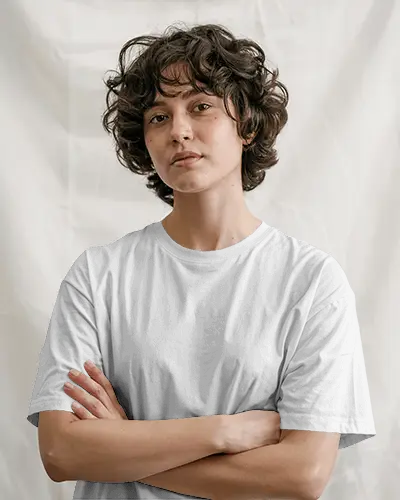 Studio White Backdrop Tshirt Mockup Female Model Crossed Arms Bold Expression