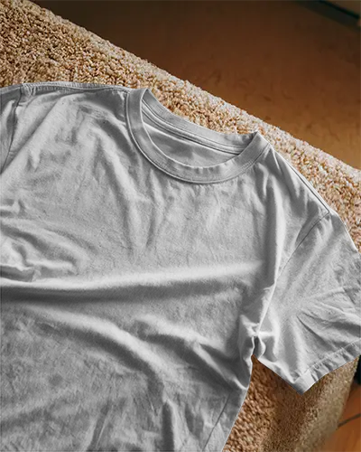 Lifestyle Tshirt Mockup White Shirt Draped Over Textured Sofa In Natural Light