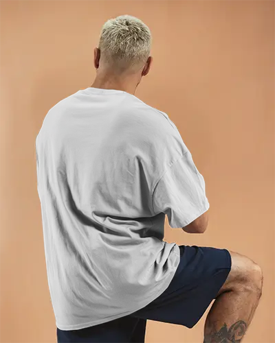Back View Tshirt Mockup Male Model In White Tee Posing On One Knee Warm Peach Background