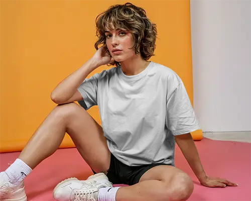 Sporty Studio Tshirt Mockup Female Model Sitting On Pink Floor With Orange Backdrop