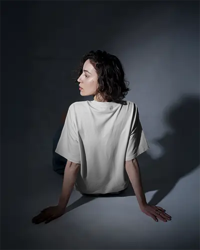 Back View Tshirt Mockup Female Model In Spotlight Studio Setting