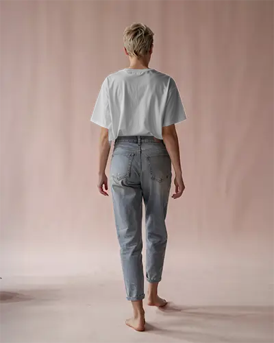 Soft Pink Studio Back Tshirt Mockup Blonde Woman In White Tee And Jeans Walking Away Barefoot In Minimal Setting Soft Lighting And Clean Composition