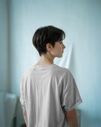 Back View Tshirt Mockup Female Model In Minimalist Room Soft Blue Tones Clean Design Template For Branding And Custom Print Showcase