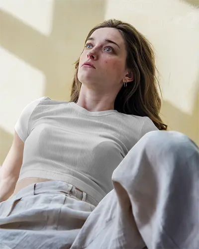 Natural Light T Shirt Mockup Woman Lying On Floor In White Ribbed Tee Relaxed Pose Against Textured Yellow Wall