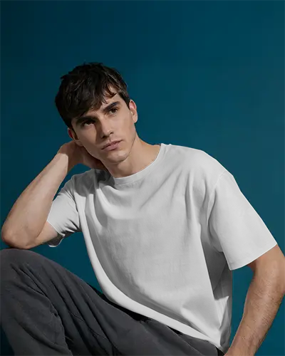 Introspective Pose Tshirt Mockup Man In White Tshirt And Dark Pants On Muted Blue Backdrop