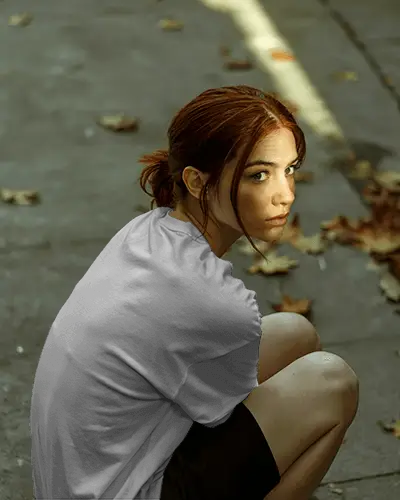 Moody Daylight Tshirt Mockup Female Model Back View Seated On Ground With Fallen Leaves