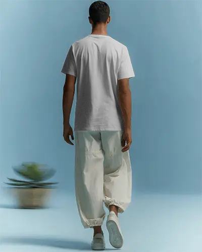 Back View Tshirt Mockup Male Model In Relaxed Pose Clean Aesthetic With Soft Light And Neutral Tones