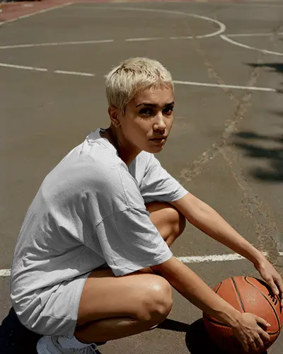 Outdoor Basketball Court Tshirt Mockup Female Model Squatting With Ball Sporty Urban Fashion Scene
