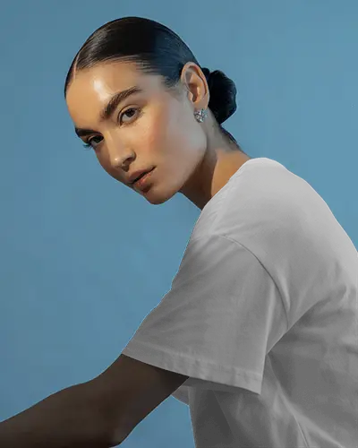 Elegant Studio Tshirt Mockup Female Model In Side Pose On Blue Backdrop Soft Lighting High Fashion Look