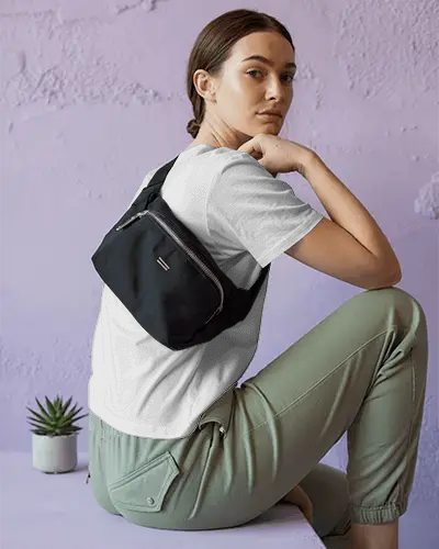 Casual Outfit Tshirt Mockup Featuring Back Design Hidden Under Sling Bag On Young Female Model Against Pastel Wall