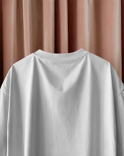 White Tshirt Mockup Boxy Fit Hanging Against Soft Pink Velvet Curtains Rear Print Display Minimal Styling Casual Elegance