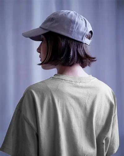 Cool Toned Curtain Background T Shirt Mockup Female Model In Cap Back View Soft Diffused Lighting Casual Urban Style