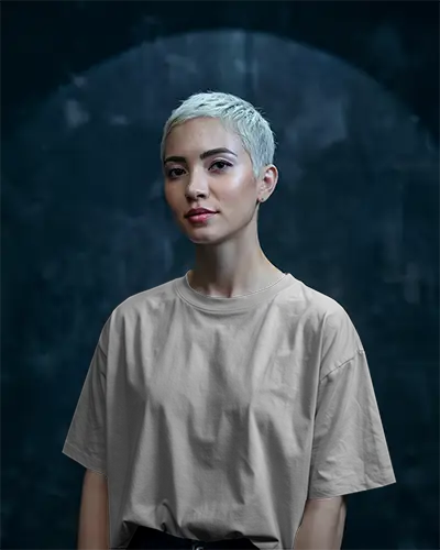 Studio Lit Fashion Forward T Shirt Mockup Female Model With Platinum Hair In Front Of Textured Dark Backdrop Confident And Modern Aesthetic