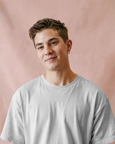 Studio Soft Light T Shirt Mockup Male Model Smiling With Pink Textured Backdrop Casual And Friendly Vibe