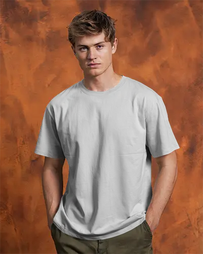 Tshirt Mockup Male Model Front View Hands In Pockets Against Textured Orange Backdrop Confident And Casual Pose