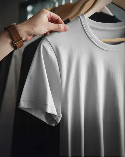 Minimal Wardrobe Tshirt Mockup Hand Picking White Tee From Clothing Rack Soft Lighting And Selective Focus