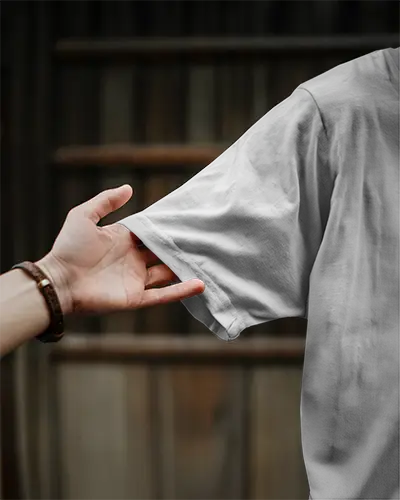 Closeup Tshirt Mockup Hand Pulling Shirt Sleeve Wooden Background Natural Light Focus Sleeve Print