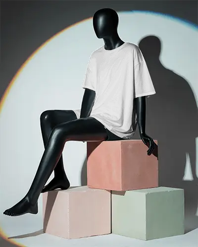 Fashion Forward T Shirt Mockup Seated Black Mannequin On Geometric Pedestals Under Focused Light Circle