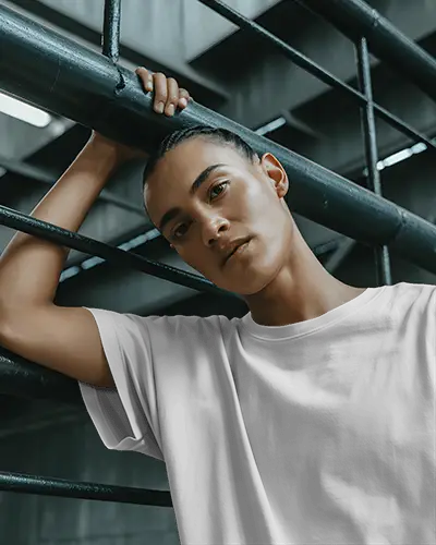 Urban Industrial T Shirt Mockup Model Posing Against Metal Railings In Moody City Setting