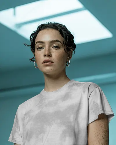 Skylight Lit T Shirt Mockup Female Model Gazing Forward In Modern Blue Toned Architectural Space