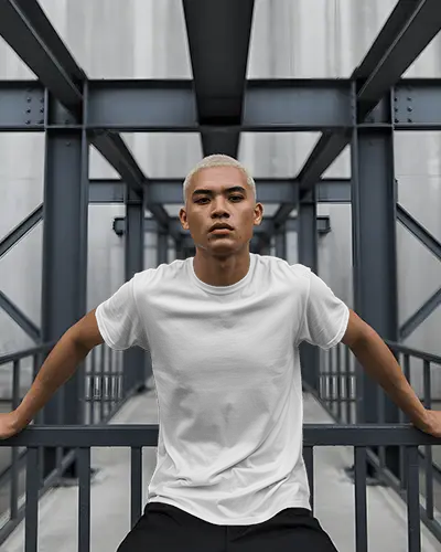 Urban Architecture T Shirt Mockup Confident Model On Railing Surrounded By Steel Framing