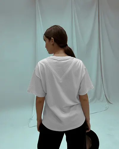 Minimal Studio T Shirt Mockup Female Model Facing Back In Loose Fit Shirt With Curtains