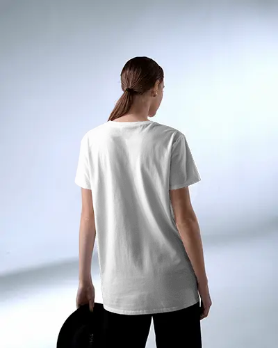 Rear View Studio T Shirt Mockup Woman Holding Hat Standing In Soft Even Light Backdrop