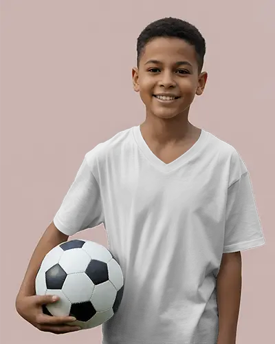 Smiling Boy Wearing V Neck T Shirt Mockup Holding Soccer Ball Against Muted Pink Backdrop