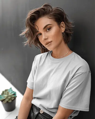 t-shirt-mockup-female-model-posing-confidently-against-dark-wall-with-succulent-in-frame