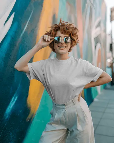 t-shirt-mockup-redhead-female-model-smiling-in-sunglasses-against-bright-street-mural