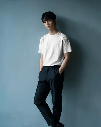 Casual Lean Tshirt Mockup Asian Male Model Hands In Pockets Minimal Blue Wall Background