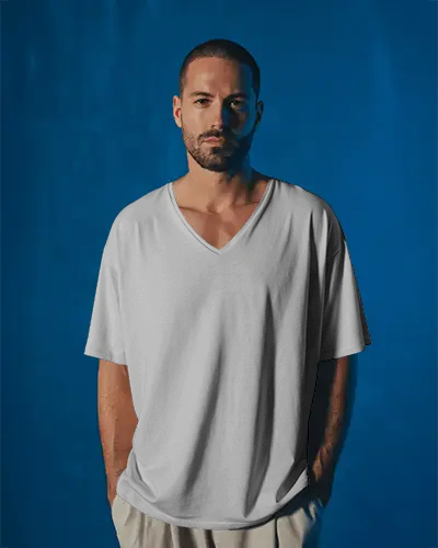 minimalist-v-neck-t-shirt-mockup-man-standing-casually-in-dark-blue-backdrop