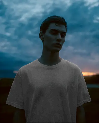 moody-dusk-t-shirt-mockup-male-model-in-twilight-skyline-backdrop-brooding-contemporary-style
