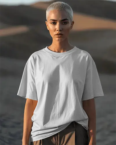 desert-sunset-t-shirt-mockup-female-model-short-hair-strong-gaze-sandy-landscape-bold-vibe