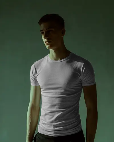 Moody Lighting T Shirt Mockup Male Model Looking Away In Shadowed Studio Minimal Modern Vibe