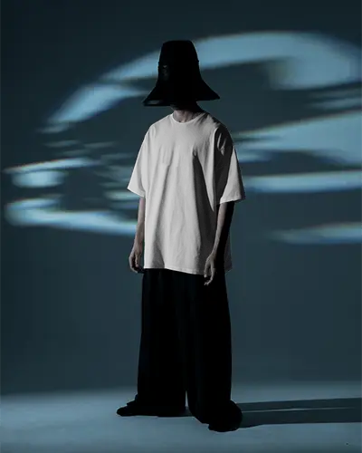Vant Garde Darkroom Tshirt Mockup Male Model With Wide Pants And Oversized Hat Moody Lighting