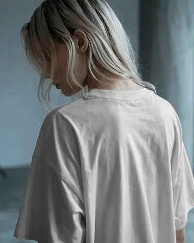 Moody Backview Tshirt Mockup Female Model In Loose Fit Against Minimal Studio Light