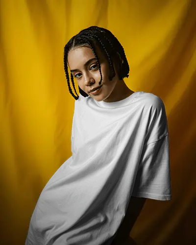 Yellow Backdrop Tshirt Mockup Female Model Posing In Oversized Tee Against Bold Fabric Curtain