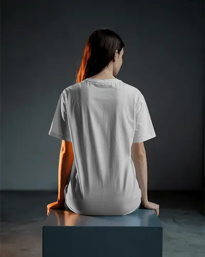 Cinematic Backview Tshirt Mockup Female Model Sitting On Pedestal Under Dramatic Lighting