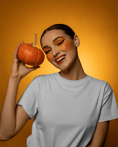 Cheerful Woman Showcasing Pumpkin With Autumn Makeup For Halloween Mockup