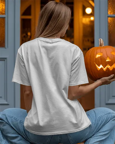 Spooky Halloween Pumpkin T Shirt Mockup Showcasing Person Holding Carved Jack O Lantern Outside